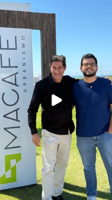 Cliente da Macafé Urbanismo ao lado de integrante da Canoa Comunicação em frente à placa do empreendimento